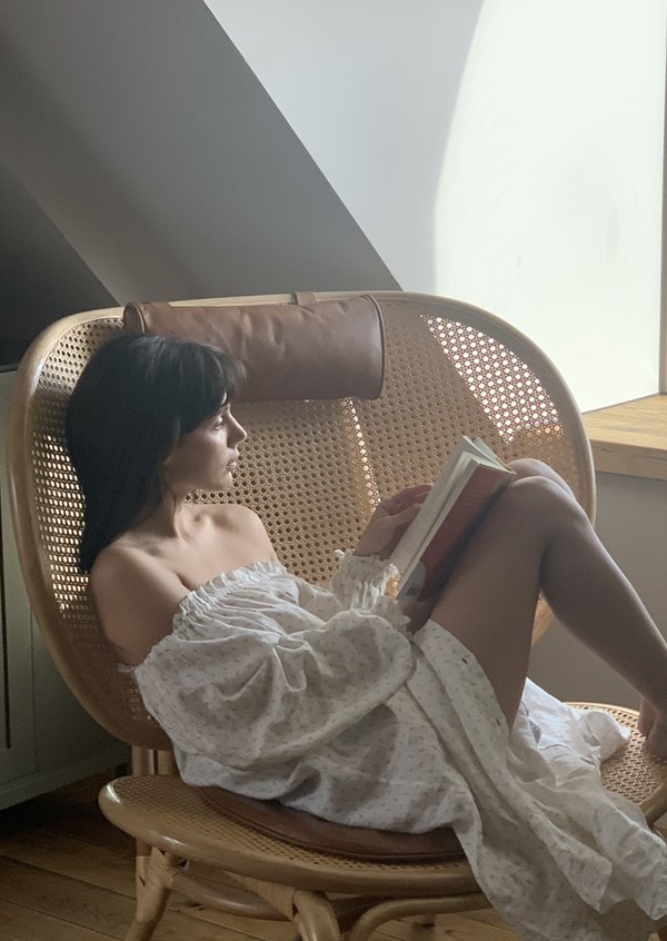Relaxing in a woven chair, reading in soft natural light