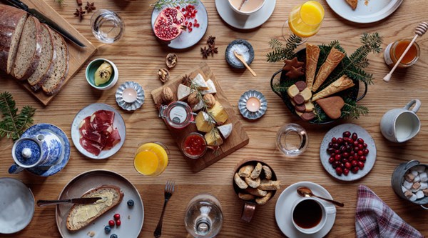 Inviting breakfast spread with fresh bread, cheeses, fruit, and coffee.